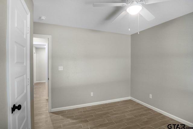spare room with ceiling fan, baseboards, and wood finished floors