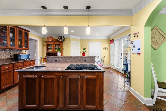 1122 S Chilton, Tyler, TX 75701 - kitchen with gas stovetop, a sink, a center island with sink, baseboards, and backsplash
