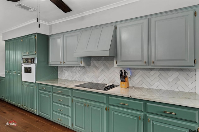 kitchen with crown molding, black electric cooktop, dark hardwood / wood-style floors, custom range hood, and oven