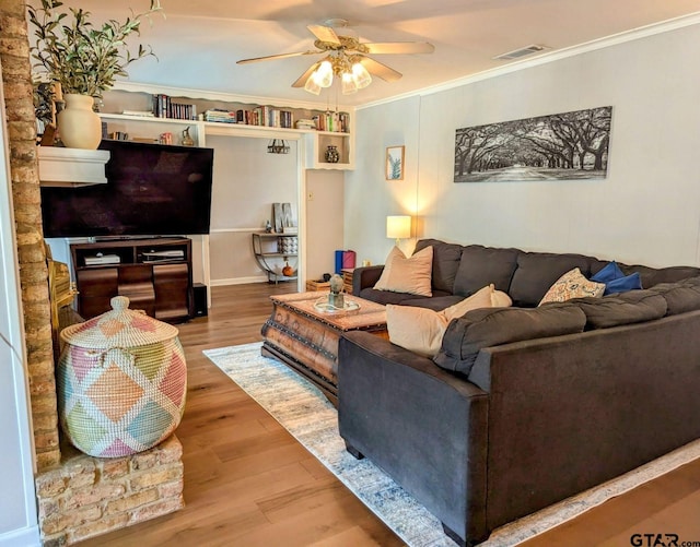 living room featuring ornamental molding, wood-type flooring, and ceiling fan