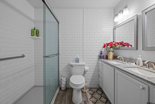 bathroom with a shower with shower door, wood-type flooring, toilet, and vanity