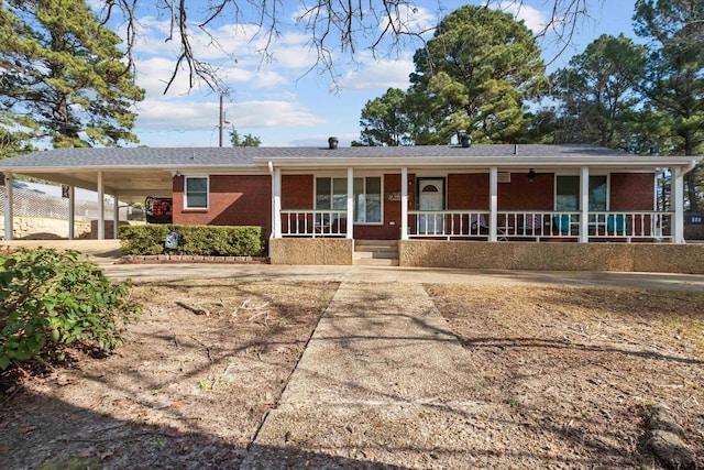 ranch-style house featuring a porch and a carport