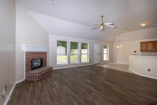 221 Maggie Cir, Flint, TX 75762 - unfurnished living room with vaulted ceiling, dark wood-style floors, a fireplace, ceiling fan, and a chandelier