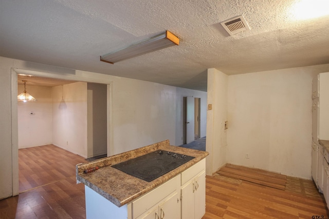 14832 Fm 2661, Flint, TX 75762 - kitchen with black electric cooktop, wood finished floors, white cabinetry, and a textured ceiling