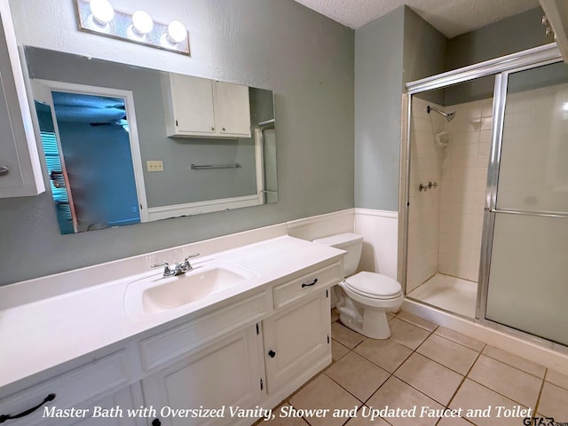 3900 S Donnybrook Ave, Tyler, TX 75703 - bathroom featuring a stall shower, toilet, vanity, tile patterned flooring, and a textured ceiling