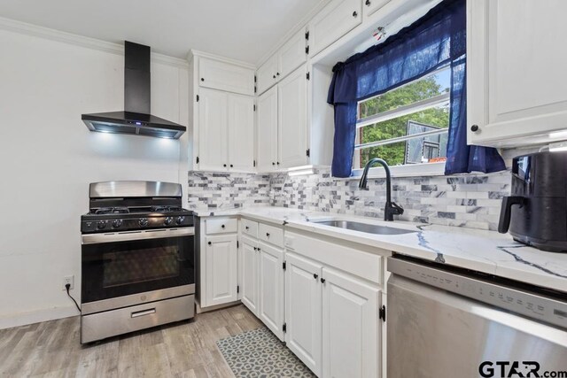 1135 E Sixth St, Tyler, TX 75701 - kitchen with wall chimney range hood, appliances with stainless steel finishes, white cabinetry, and tasteful backsplash