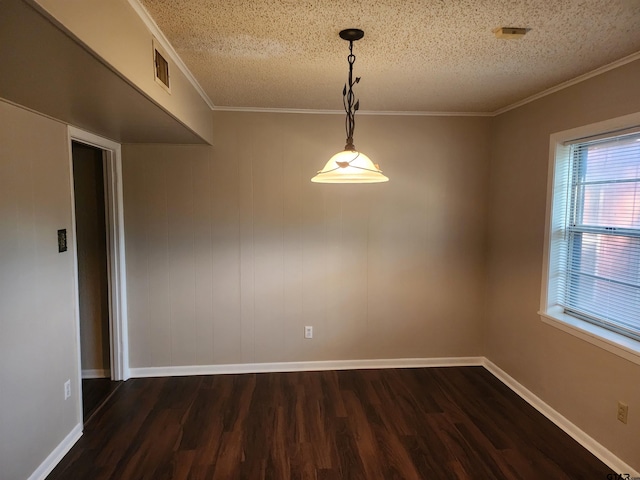 empty room with a textured ceiling, dark hardwood / wood-style floors, and crown molding