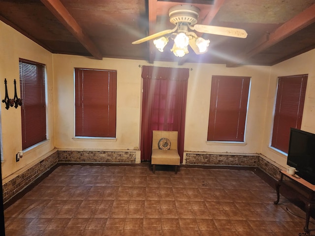 empty room with beamed ceiling and ceiling fan