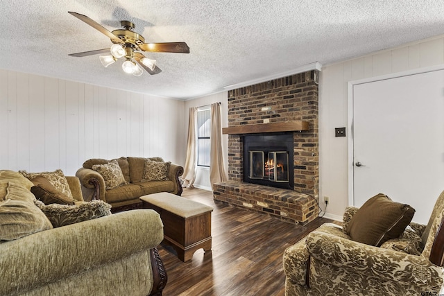 living room featuring ceiling fan, dark hardwood / wood-style floors, a textured ceiling, and a fireplace