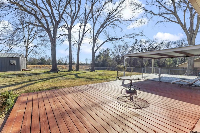 wooden terrace featuring a yard and a storage unit