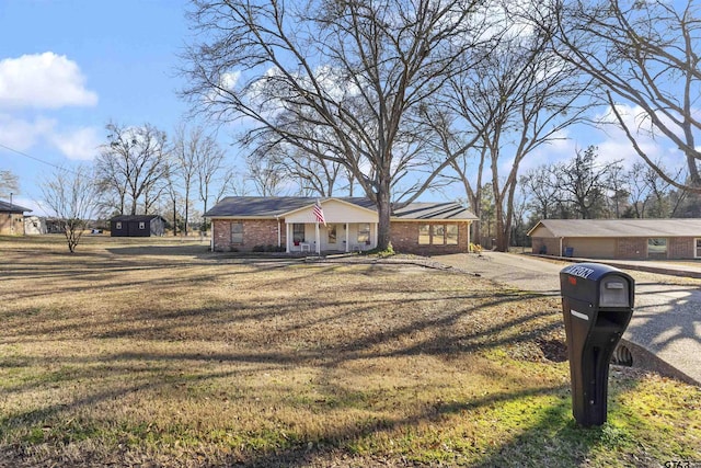 ranch-style house with a porch and a front lawn