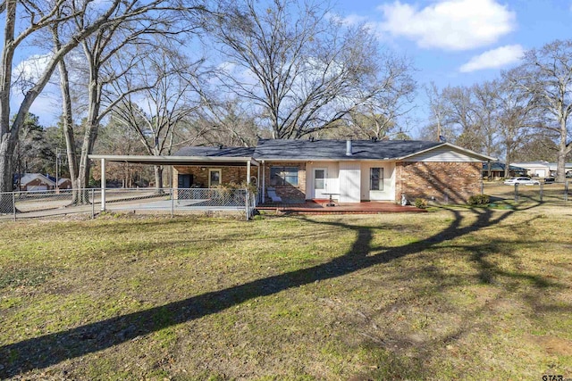 rear view of property featuring a carport and a yard