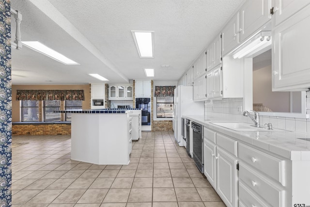 kitchen featuring white cabinetry, sink, tile countertops, and light tile patterned floors