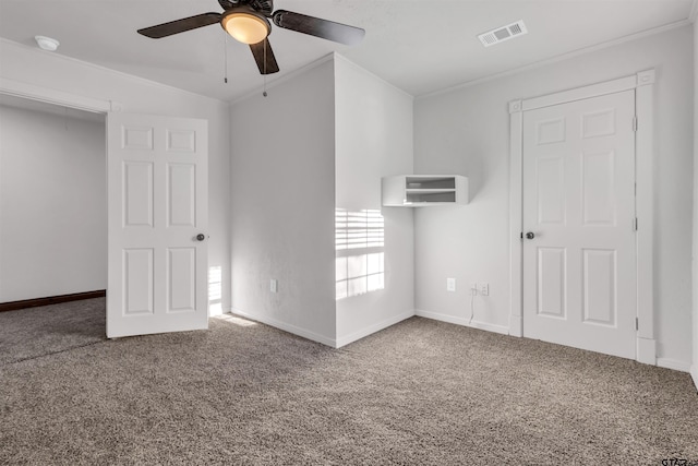 carpeted spare room with baseboards, ceiling fan, visible vents, and ornamental molding