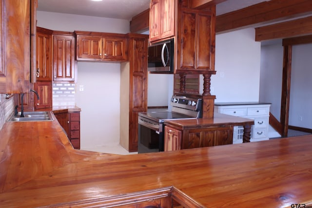 kitchen featuring tasteful backsplash, sink, kitchen peninsula, and appliances with stainless steel finishes