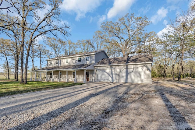 view of front of property with driveway, a front yard, covered porch, and an attached garage