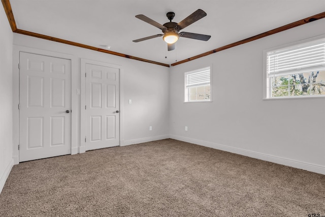 unfurnished bedroom featuring baseboards, ornamental molding, and carpet
