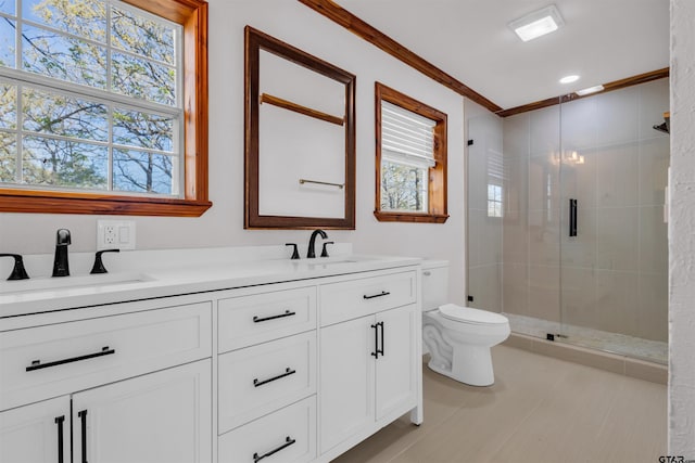 full bath featuring double vanity, a sink, toilet, and a shower stall