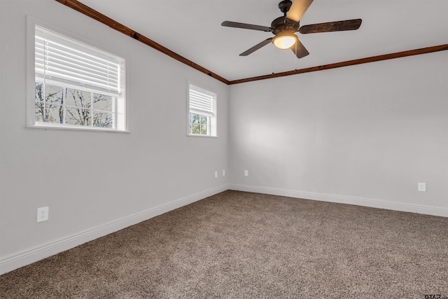 unfurnished room featuring baseboards, crown molding, ceiling fan, and carpet flooring