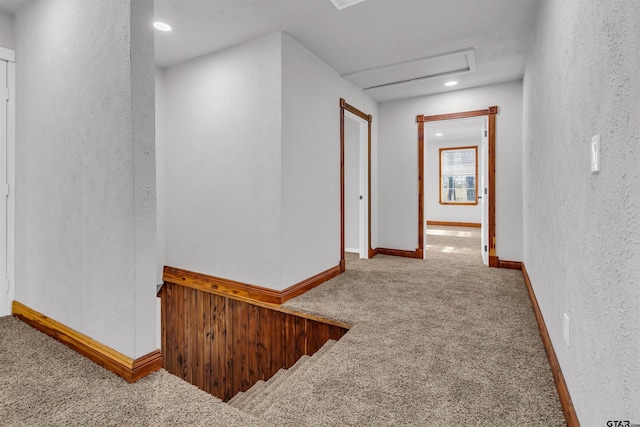 hall with a textured wall, carpet flooring, attic access, baseboards, and recessed lighting