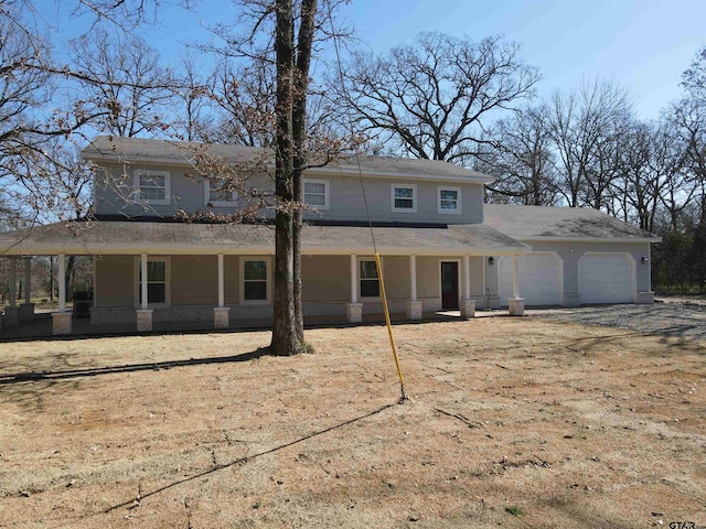 view of front of property with a garage, covered porch, and a front yard