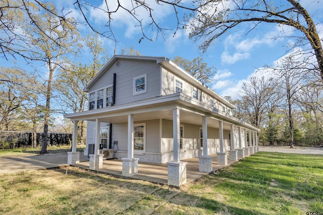 view of front facade featuring a front yard, a porch, and ac unit