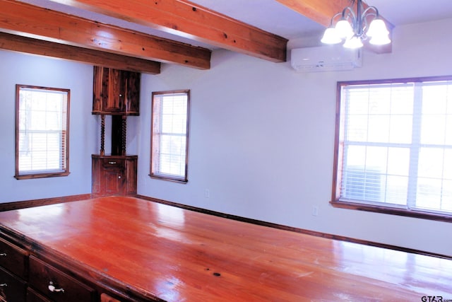 interior space featuring an inviting chandelier, beam ceiling, light hardwood / wood-style flooring, and an AC wall unit