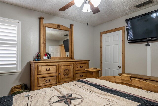 bedroom with a textured ceiling and ceiling fan