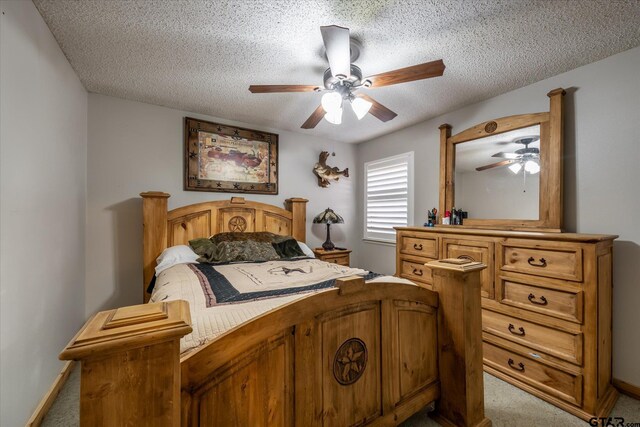 carpeted bedroom featuring ceiling fan and a textured ceiling