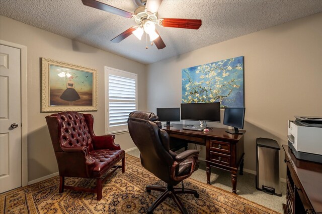 office space featuring a textured ceiling, light colored carpet, and ceiling fan