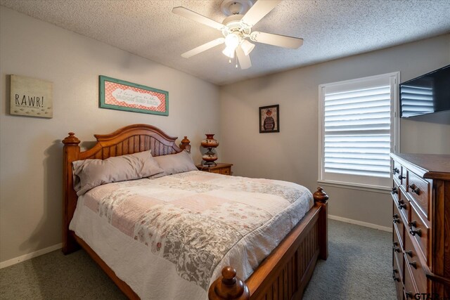 bedroom with a textured ceiling, ceiling fan, and dark colored carpet