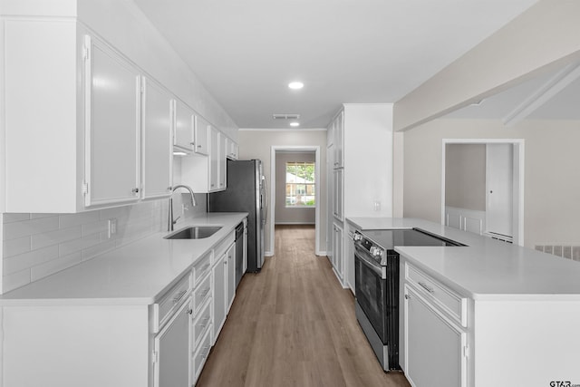 4816 Picadilly Pl, Tyler, TX 75703 - kitchen with stainless steel appliances, a sink, a peninsula, light countertops, and light wood-style floors