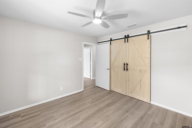 4816 Picadilly Pl, Tyler, TX 75703 - unfurnished bedroom with wood finished floors, a barn door, baseboards, and ceiling fan