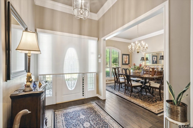 entryway featuring crown molding, a notable chandelier, and dark wood-style floors
