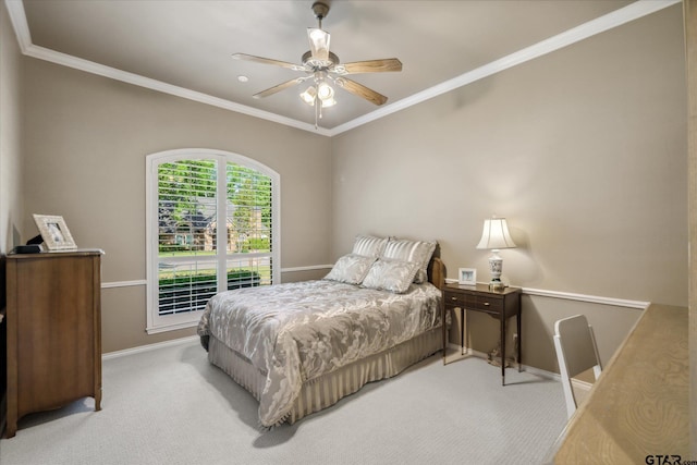 carpeted bedroom featuring baseboards, crown molding, and a ceiling fan