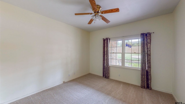 carpeted spare room featuring ceiling fan