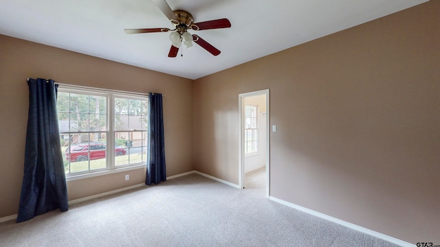 carpeted spare room with a healthy amount of sunlight and ceiling fan