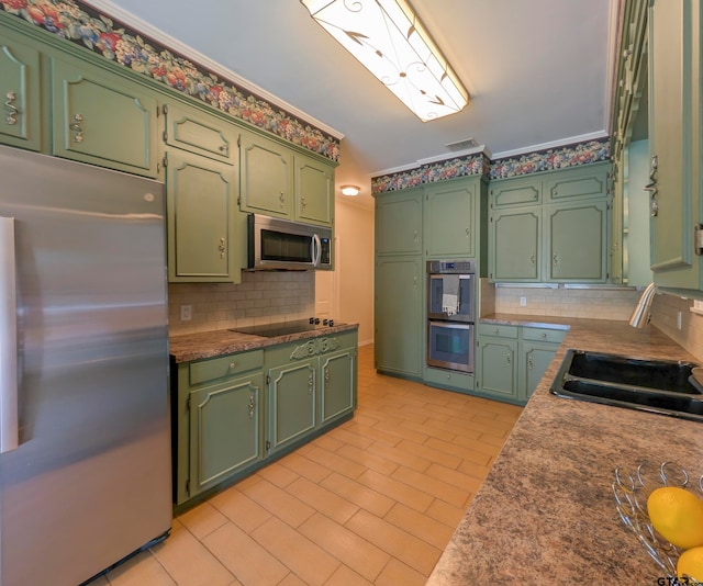 kitchen with decorative backsplash, stainless steel appliances, sink, and green cabinetry