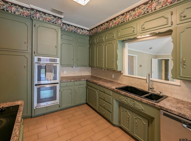 kitchen with stainless steel appliances, green cabinets, sink, ornamental molding, and backsplash