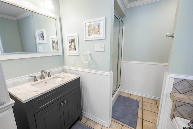 bathroom featuring vanity, crown molding, a shower with shower door, and tile patterned floors