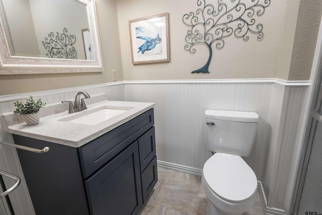 bathroom with parquet flooring, vanity, and toilet