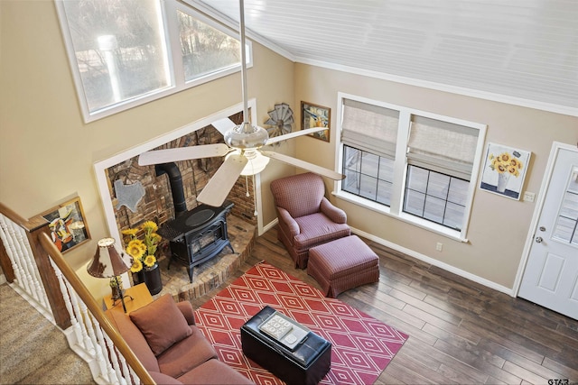 living room featuring hardwood / wood-style flooring, crown molding, and a wood stove