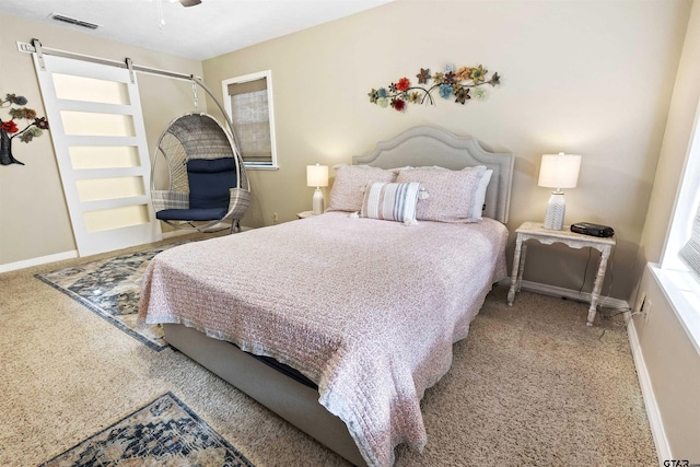 bedroom with a barn door, light colored carpet, and ceiling fan