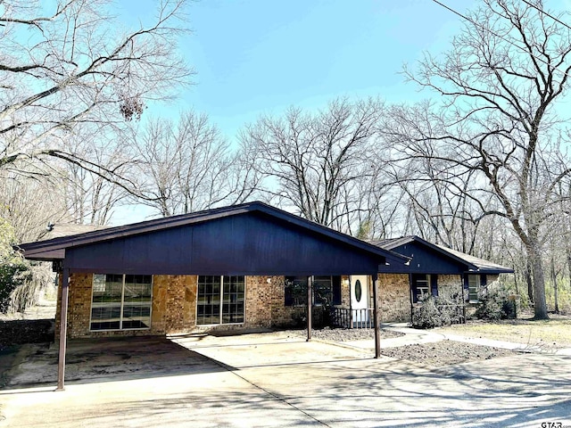 view of front of home featuring concrete driveway and brick siding