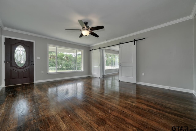 foyer entrance with a barn door, crown molding, ceiling fan, and dark hardwood / wood-style floors