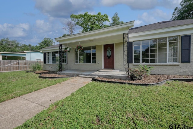 ranch-style house with a porch and a front yard