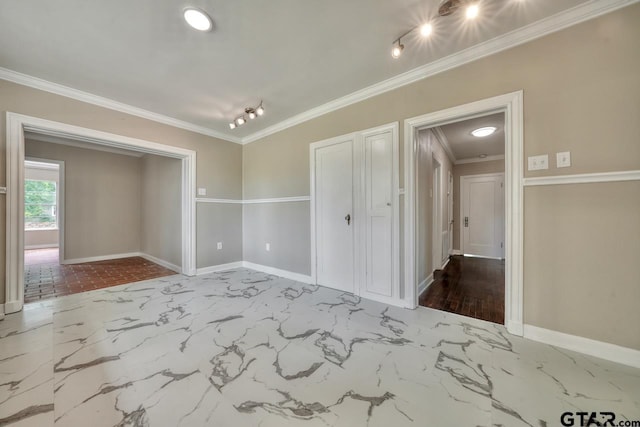 spare room with ornamental molding and rail lighting