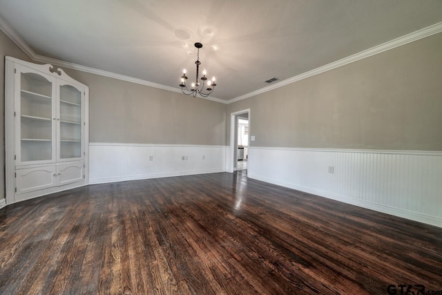 unfurnished room featuring a chandelier, dark wood-type flooring, and ornamental molding