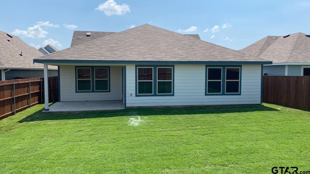 rear view of house with a yard and a patio