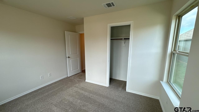 unfurnished bedroom with carpet floors and a closet